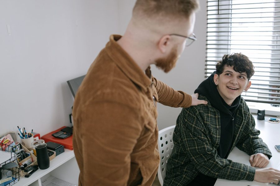 An Academy practitioner coaching an apprentice at a desk